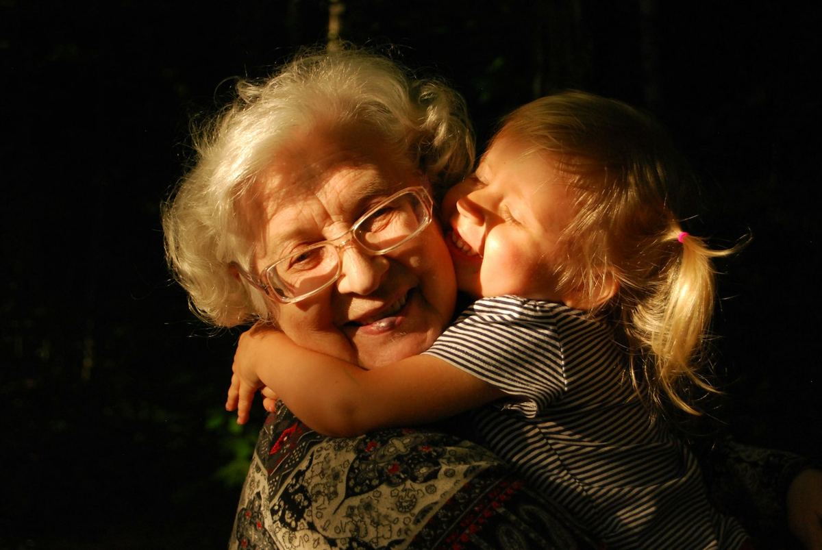 An older woman hugging a young family member